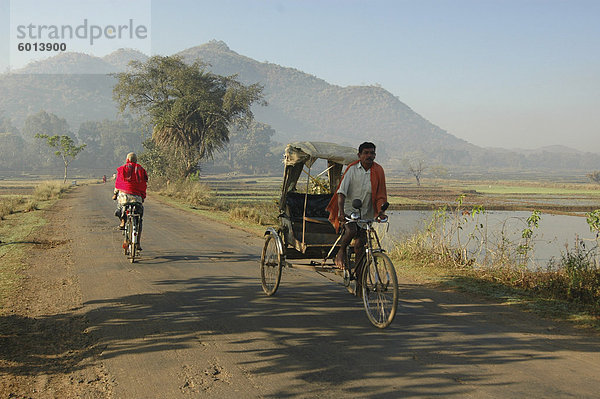 Am frühen Morgen Rikscha-Wallahs übergeben einander im ländlichen Gegend in der Nähe von Baliguda  Orissa  Indien  Asien