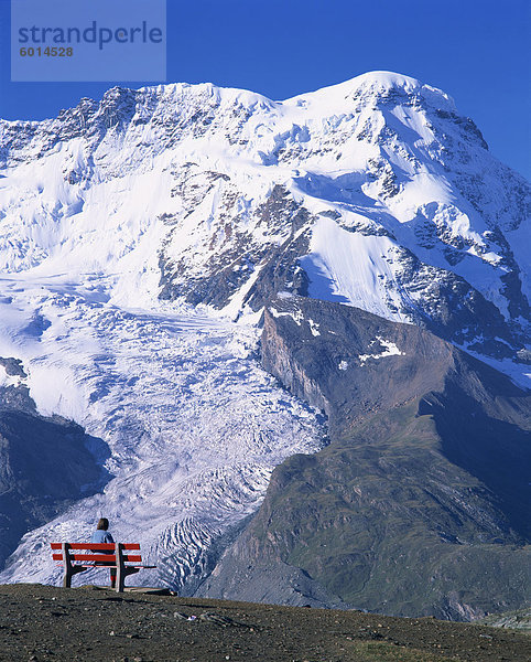 Wanderer auf Bank  das Breithorn und Breithorn Gletscher  Rotenboden  Zermatt  Wallis  Schweiz  Europa