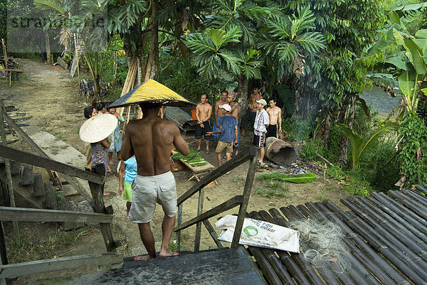 IBAN Häuptling schließt andere Dorfbewohner teilen einen Witz und Kochen im Regen  Lemanak Flusses  Sarawak  Malaysia Borneo  Malaysia  Südostasien  Asien