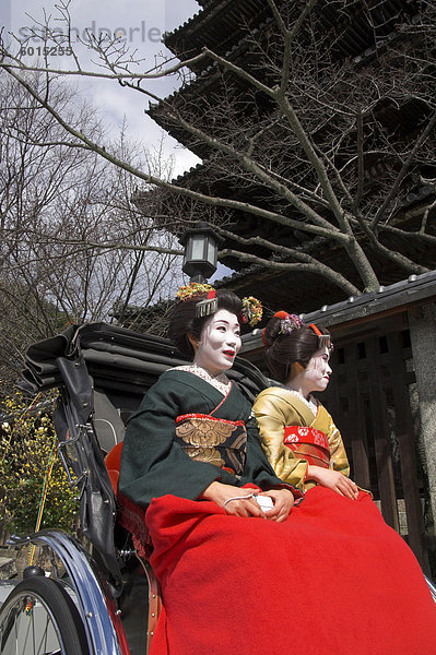 Zwei Geishas in traditionellen Kleidern posieren auf eine Rikscha  Higashiyama-Viertel  Kyoto  Kansai  Honshu  Japan  Asien