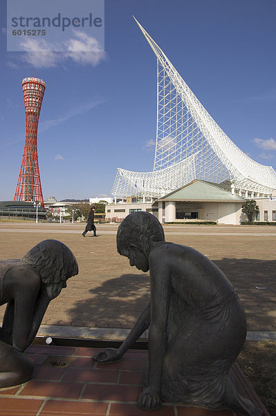 Bronzefiguren von zwei Kindern spielen Murmeln mit dem Kobe Maritime Museum und im Hintergrund  Meriken Park  Kobe-Hafen Turm harbour  Kobe  Kansai  Honshu  Japan  Asien