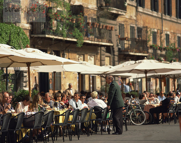 Touristen am Bürgersteig Café auf der Piazza Navona in der Stadt Rom  Lazio  Italien  Europa