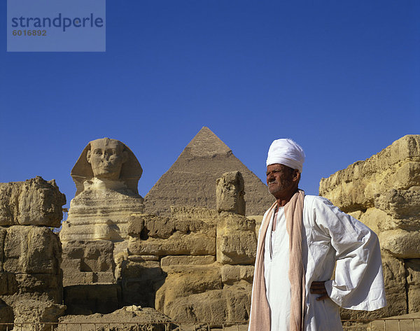 Porträt der Mann in traditioneller Kleidung vor die große Sphinx und die Cephren-Pyramide in Gizeh  UNESCO Weltkulturerbe  Kairo  Ägypten  Nordafrika  Afrika