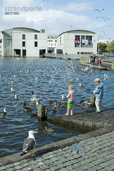 Radhus (Rathaus) mit Kindern  die Fütterung von Vögeln  Reykjavik  Island  Polarregionen