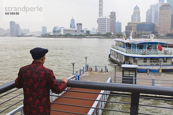 Ein Mann beobachtete Fähren überqueren das Fluss Huangpu  Shanghai  China  Asien