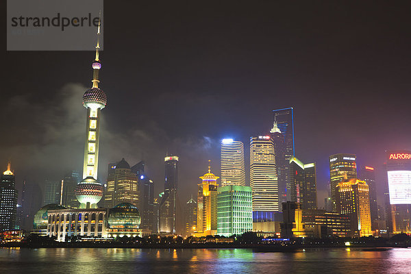 Pudong-Skyline bei Nacht über den Huangpu-Fluss  Oriental Pearl Tower auf Links  Shanghai  China  Asien