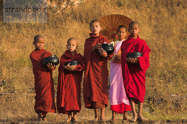 Nonne mit Neuling Mönche halten Almosen Schalen auf Mingun Paya  Mingun  Mandalay  Myanmar (Birma)  Asien