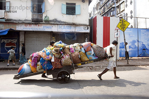 Laundrymen (Dhobi Wallahs)  hölzerne ziehen Warenkorb bei beladenem Wäsche von den Hotels zum Waschen bei Mahalaxmi Dhobi Ghat (Indien)  Mumbai  Indien  Asien