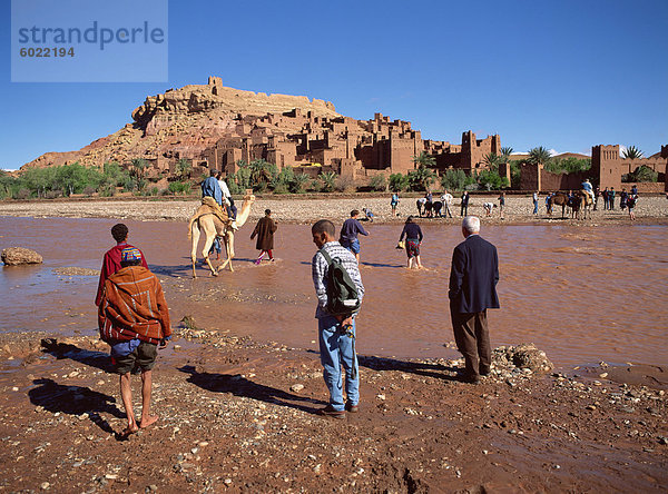 Touristen kreuzen Fluss Asif Mellah Kasbah Ait Ben Haddou  UNESCO-Weltkulturerbe  in der Nähe von Ouarzazate  Marokko  Nordafrika  Afrika zu besuchen