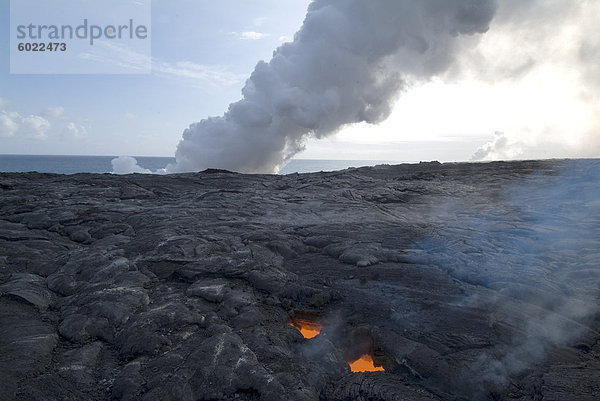 Oberlicht  Blick durch gekühlte Lava bis geschmolzene Lava unten  mit Federn des Dampf als Lava erreicht das Meer hinaus  Kilauea-Vulkan  Hawaii Volcanoes Nationalpark  UNESCO Weltkulturerbe  Insel Hawaii (Big Island'  Hawaii  Vereinigte Staaten von Amerika  Nordamerika