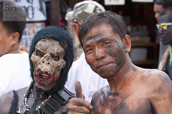 Porträt zweier Männer  maskiert man  das andere mit Ruß verschmiert auf seinem Gesicht während der Ati-Atihan Festival  ein jährliches fest zu Ehren der Santo Nino  Boracay  Aklan  Philippinen  Südostasien  Asien