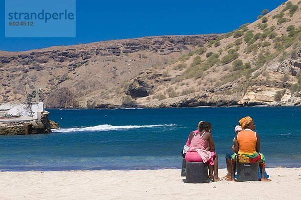 Zwei Frauen sitzen auf dem sandigen Strand reden  Tarrafal  Santiago  Cabo Verde  Afrika