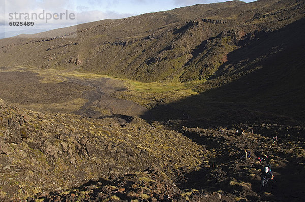 Wanderer zu Fuß durch ein Lavafeld auf den Tongariro Crossing  Tongariro-Nationalpark  der älteste Nationalpark in das Land  UNESCO-Weltkulturerbe  Taupo Volcanic Zone  Nordinsel  Neuseeland  Pazifik