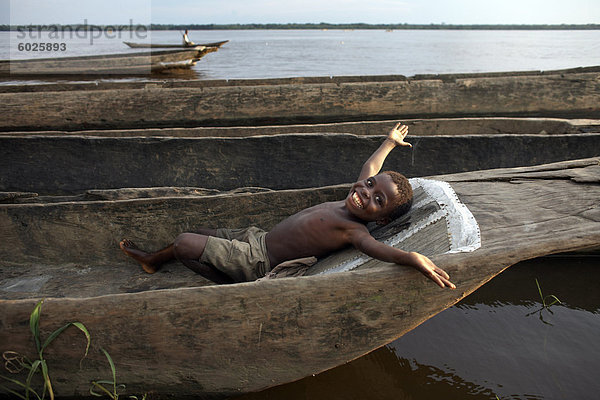 Ein Junge entspannt in einem Einbaum-Kanu auf dem Fluss Kongo  Yangambi  Demokratische Republik Kongo  Afrika