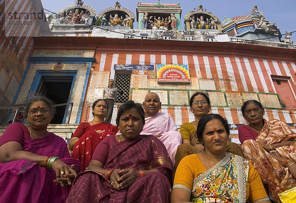 Frauen Pilgergruppe sitzen auf den Stufen des Kedar Ghat mit Tempel im Hintergrund  Varanasi  Uttar Pradesh Zustand  Indien  Asien