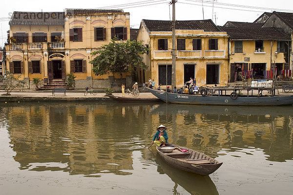 Boot auf dem Fluss vor gelb gefärbt Kolonialgebäuden  Hoi An  Vietnam  Südostasien  Asien