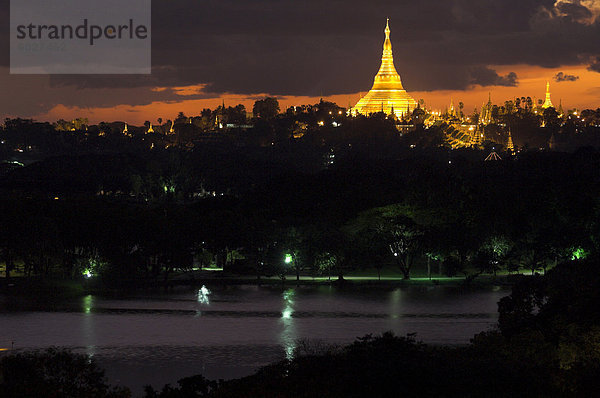 Shwedagon Paya in der Abenddämmerung mit Kandawgyi See im Vordergrund  Yangon (Rangoon)  Myanmar (Birma)  Asien