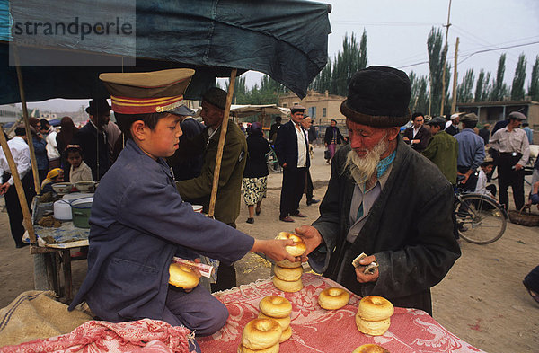 Kauf von Bagel-wie Brötchen  Sonntagsmarkt  Kashgar  Xinjiang  China  Asien