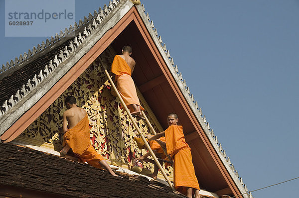 Mönche auf Dach malen die Tempel Dekorationen  Wat Mai  Luang Prabang  Laos  Indochina  Südostasien  Asien