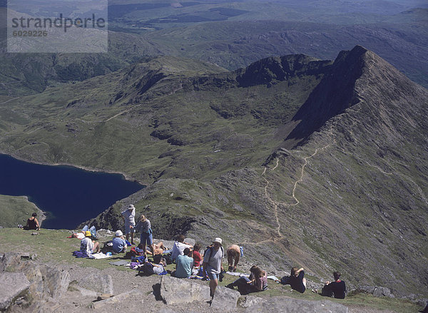 Wanderer auf dem Gipfel des Mount Snowdon  mit Llyn Llydaw Stausee und den Grat Y Lliwedd unten  entspannend  Snowdonia National Park  North Wales  Wales  Vereinigtes Königreich  Europa