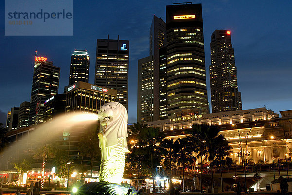 Merlion Brunnen mit Statue des halb Löwe und Fische  die ein Symbol von Singapur  mit Gebäude der Stadt darüber hinaus  Singapur  Südostasien  Asien geworden ist