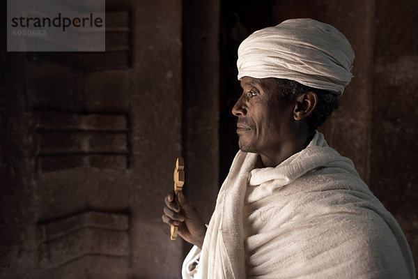 Ein Priester steht am Eingang zu den Felskirchen Kirche von Bet Amanuel  in Lalibela  Äthiopien  Afrika