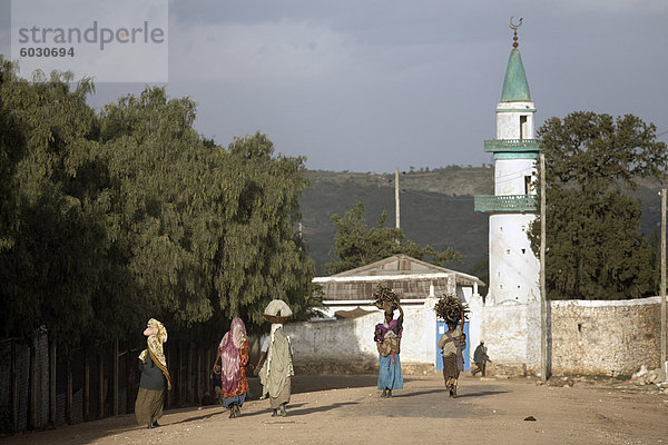 Frauen tragen ihre waren auf ihren Köpfen  in der Nähe einer Moschee in der Stadt Harar  Äthiopien  Afrika