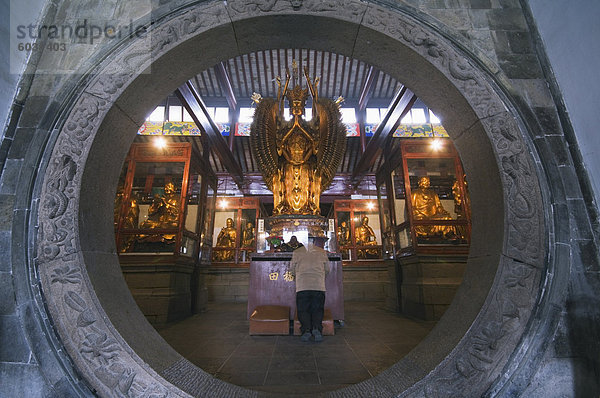 Eine Frau beten vor ein gewölbter Eingang am West Garten buddhistischer Tempel  Suzhou  Provinz Jiangsu  China  Asien