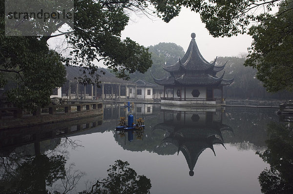 Eine Pagode spiegelt sich in das Wasser bei West Garten buddhistischer Tempel  Suzhou  Jiangsu Province  China  Asien