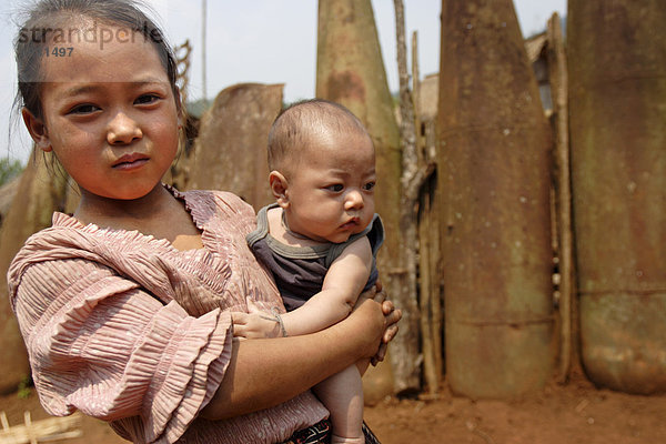 Junge Hmong Dorfbewohner vor Krieg Schrott in der nördlichen Provinz Xieng Khouang  Indochina  Laos  Südostasien  Asien