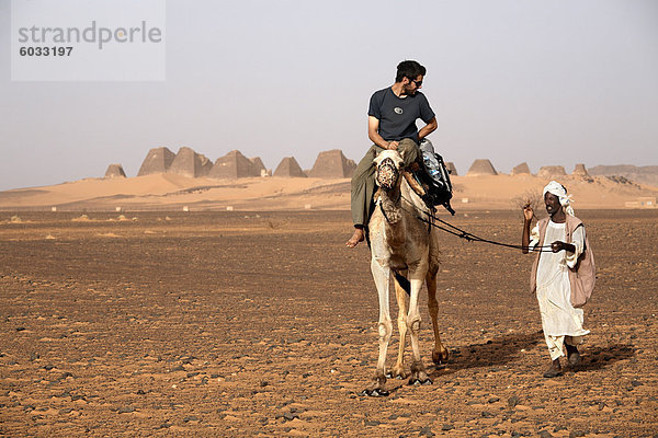 Touristen nehmen Kamelreiten bei den Pyramiden von Meroe  Sudan beliebteste Touristenattraktion  Bagrawiyah  Sudan  Afrika