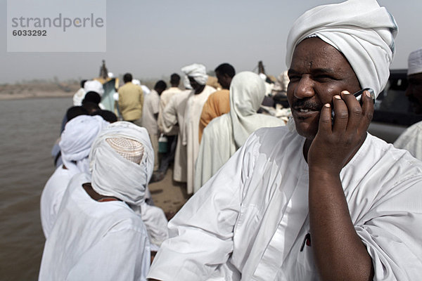 Ein sudanesischer Mann spricht auf seinem Handy während einer Nil Fähre überqueren  die Stadt der Dunqula  Sudan  Afrika