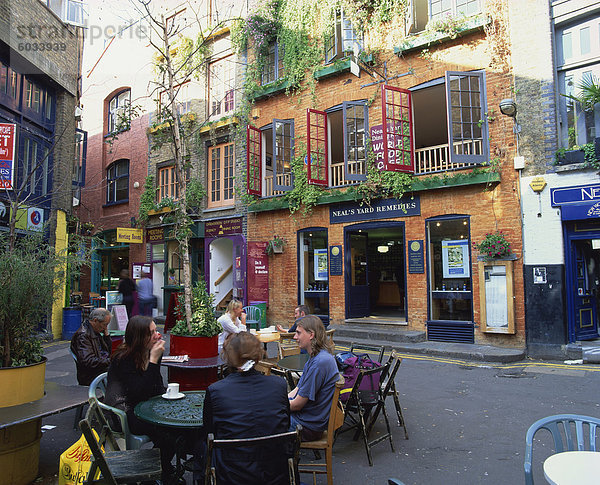 Kleine Gruppe von Menschen sitzen im Freien an Tischen eines Cafés in Neals Yard  Covent Garden  London  England  Vereinigtes Königreich  Europa