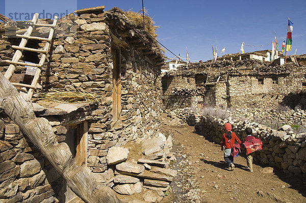 Zwei Schüler und typischen Steinhäusern am Dorf Straße  Nako  2950 m  Spiti  Himachal Pradesh  Indien  Asien