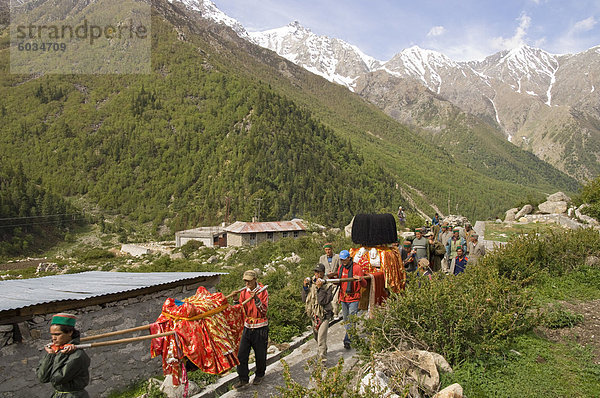 Tägliche Puja religiöse Prozession mit lokalen Gottheiten im Tal mit den schneebedeckten Bergspitzen im Hintergrund  Chitkul  3460m  Baspa Valley  Kinnaur  Himachal Pradesh  Indien  Asien