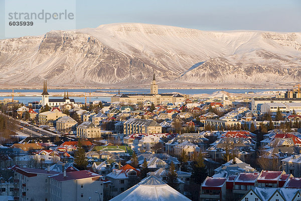 Erhöhten Blick auf die Kirchen und die Stadt  mit einer Kulisse aus Schnee bedeckten Berge  Reykjavik  Island  Polarregionen