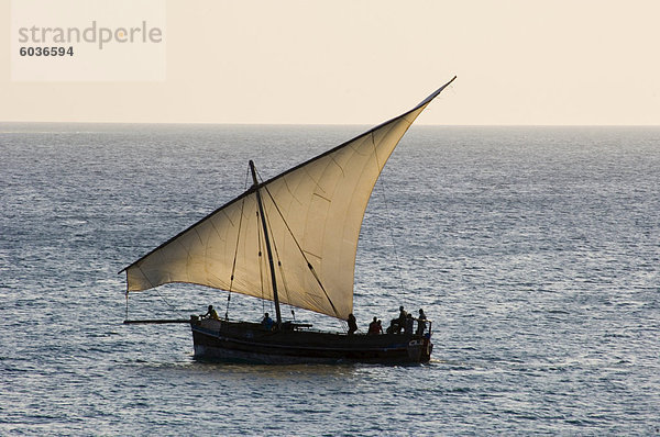 Einem traditionellen hölzernen Dhow Segeln in der Nähe von Stone Town bei Sonnenuntergang  Sansibar  Tansania  Ostafrika  Afrika