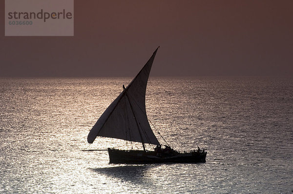 Einem traditionellen hölzernen Dhow Segeln in der Nähe von Stone Town bei Sonnenuntergang  Sansibar  Tansania  Ostafrika  Afrika