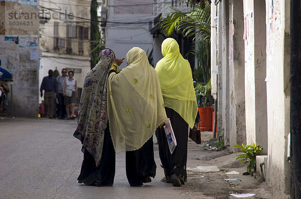 Frauen tragen bunte Kopftücher Wandern in Stone Town  Sansibar  Tansania  Ostafrika  Afrika