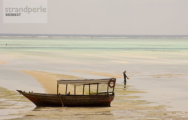 Ein altes hölzernes Boot im Meer bei Ebbe  Paje  Zanzibar  Tansania  Ostafrika  Afrika