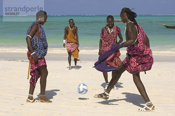 Maasai Stammesangehörigen in bunten native Kleid spielen Fußball am Strand  Afrika  Ostafrika  Paje  Zanzibar  Tansania