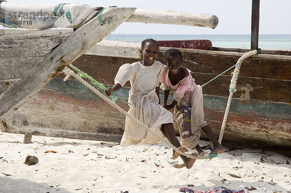 Zwei kleine Mädchen auf einem provisorischen Schwingen am Strand von Nungwi  Sansibar  Tansania  Ostafrika  Afrika