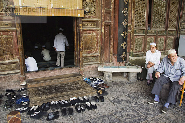 Außenaufnahme Mann Wohnhaus Schuh Gebet Gemeinschaft Entdeckung groß großes großer große großen China Islam Asien links Moschee Viertel Menge