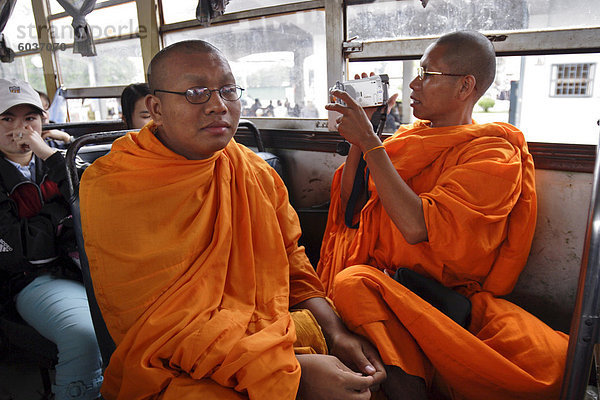 Ein buddhistischer Mönch verwendet seine Camcorder auf einen Bus in Vientiane  Laos  Indochina  Südostasien  Asien