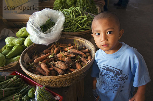 Kleine Junge Anbieter am Gemüse Stall in der Lebensmittel-Markt  Bontoc  Cordillera Berge  Mountain Province  Luzon  Philippinen  Südostasien  Asien