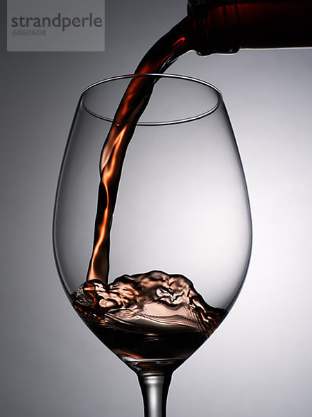 Nahaufnahme von roten Wein in Glas Wein gegossen wird