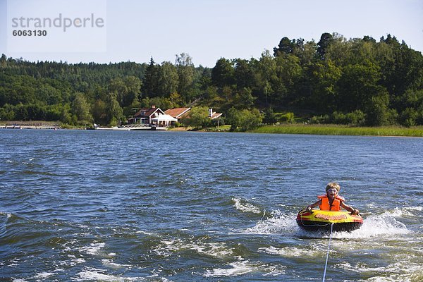 Junge sitzt im kleinen Schlauchboot Boot