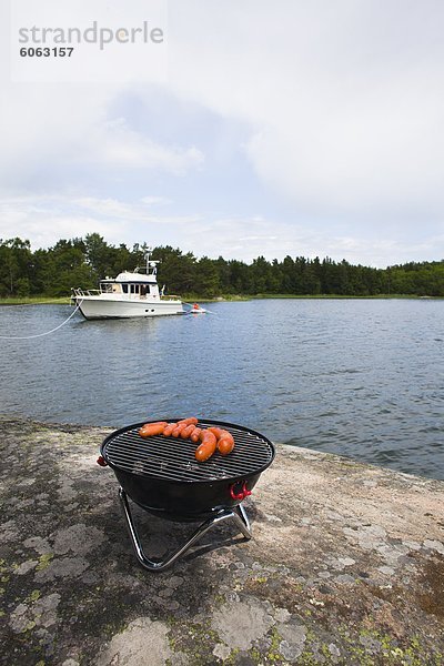 Würstchen auf Barbecue-Grill am Ufer