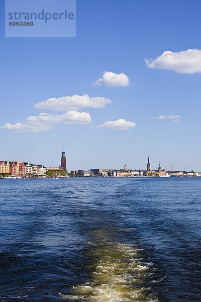 Wake Links per Boot am Meer mit Stadt im Hintergrund