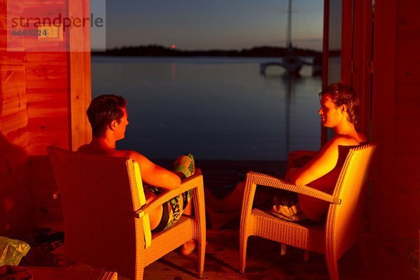 Zwei junge Männer entspannend auf Stühlen auf dem Seeweg